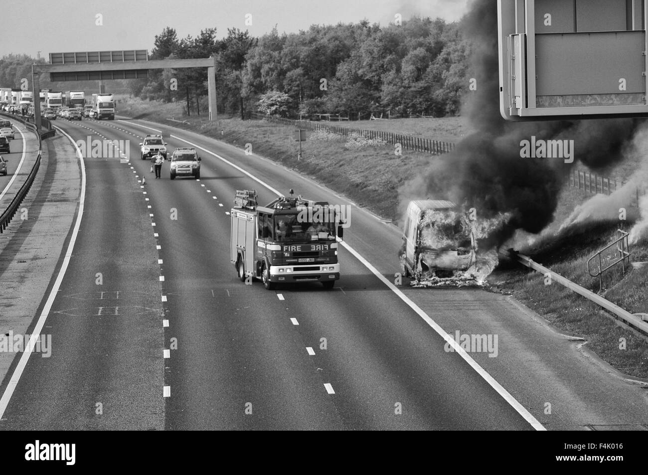 Firemen putting out a van fire on Motorway Stock Photo