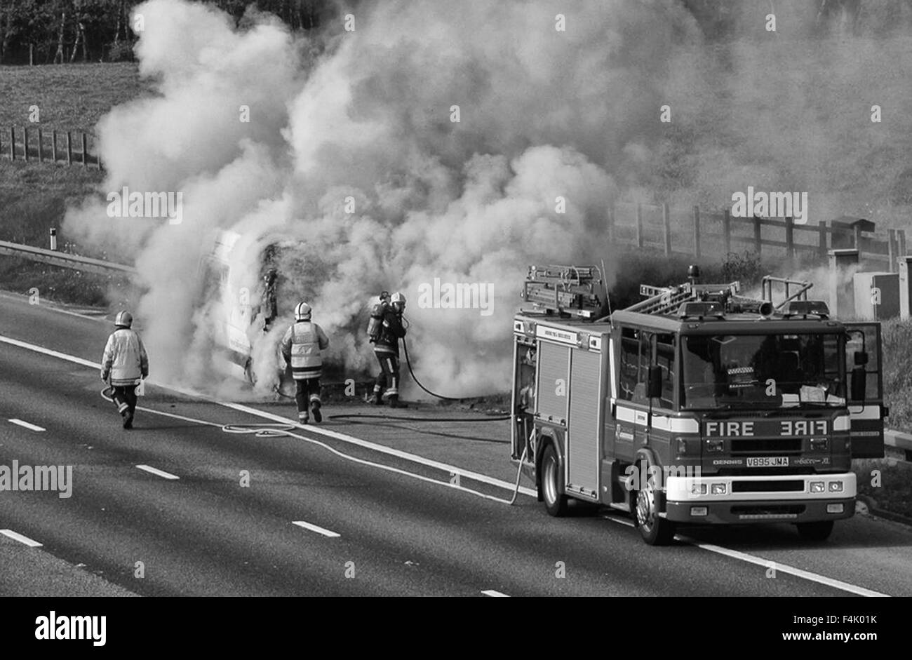 Firemen putting out a van fire on Motorway Stock Photo
