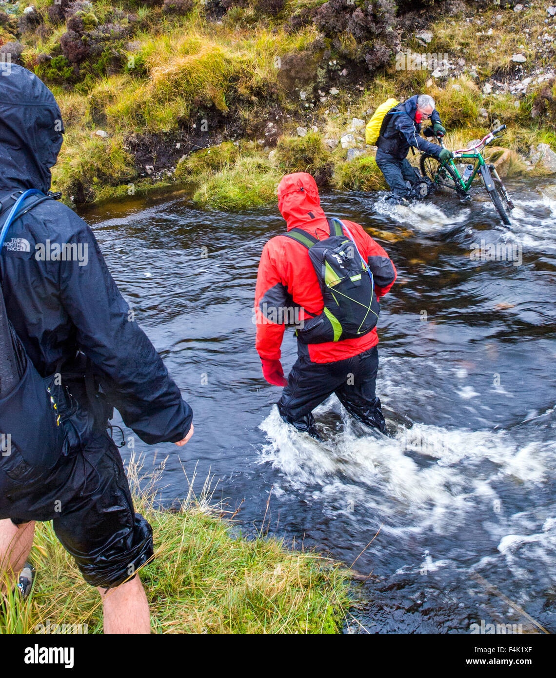 River crossing whilst bike-packing in Strath Dionard NW Scotland Stock Photo