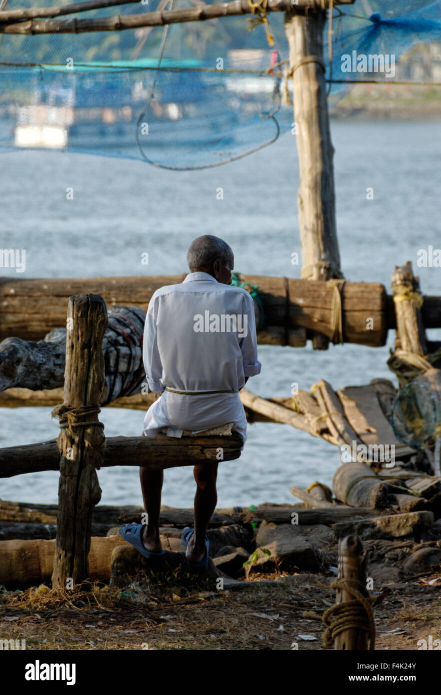 Old man sitting on wooden branch Stock Photo