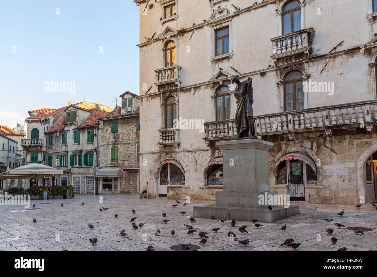 Pigeons in front of a statue of Marko Marulic at a square at the Diocletian's Palace in Split, Croatia. Stock Photo