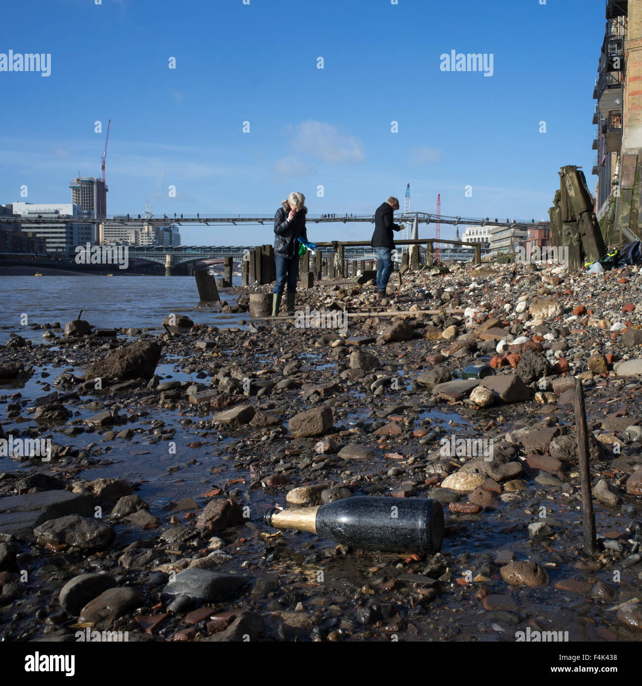 Low tide at the Thames Bank below the Millenium Bridge showing modern mudlarks hunting for hidden treasure exposed by the tide Stock Photo