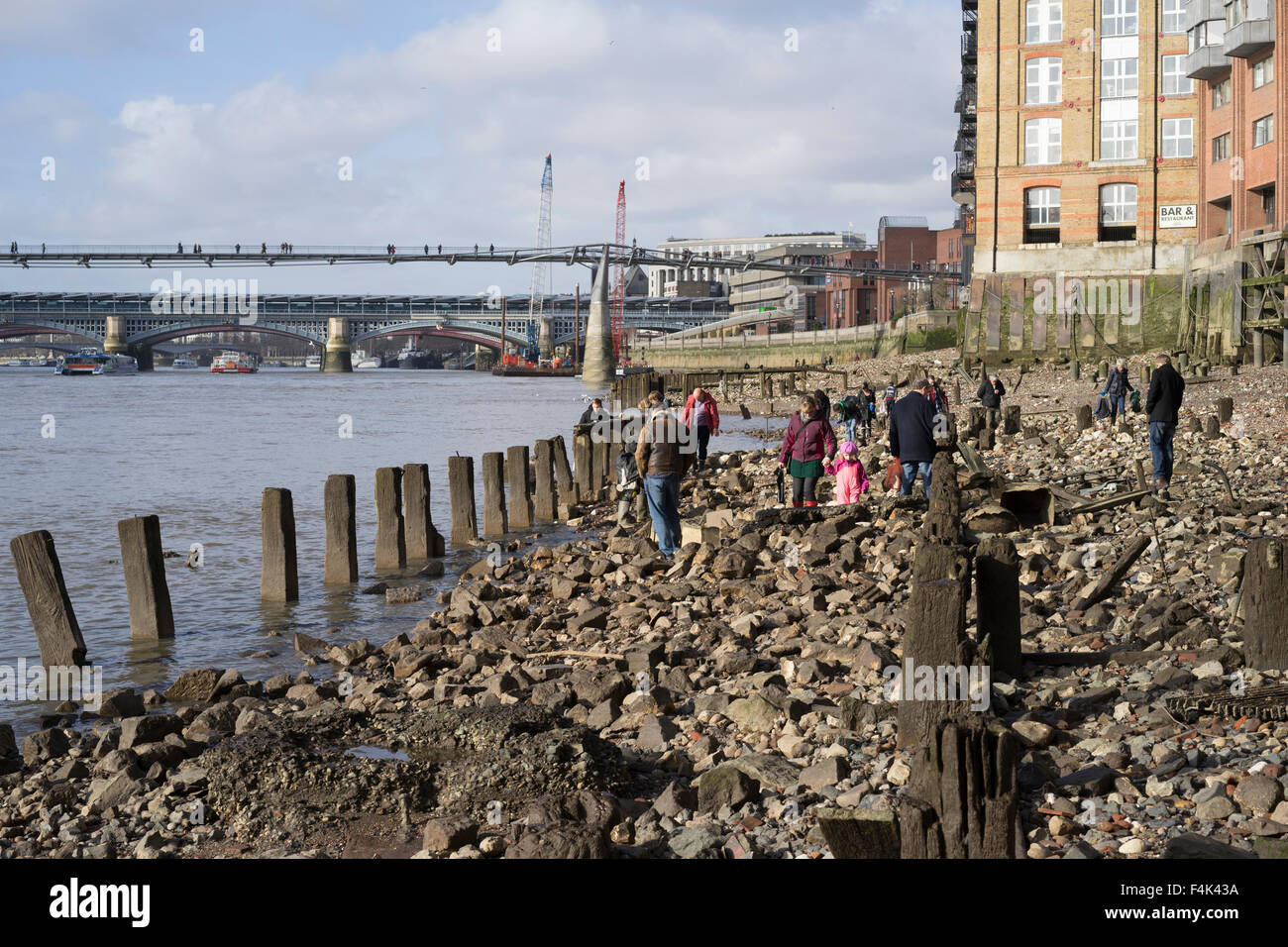 Low tide at the Thames Bank below the Millenium Bridge showing modern mudlarks hunting for hidden treasure exposed by the tide Stock Photo