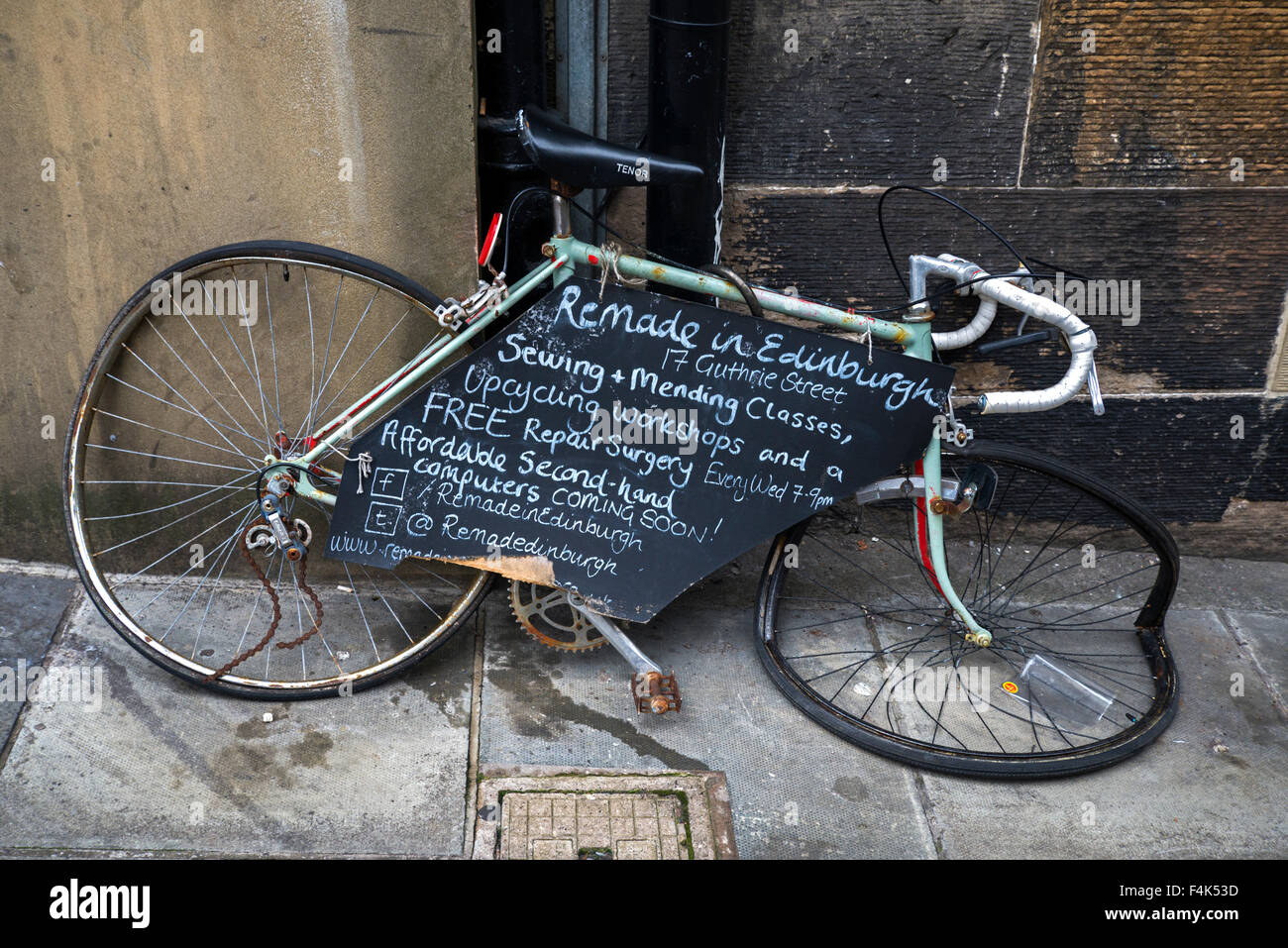 A bicycle - now trashed - being used to advertise an upcycling and recycling service in Edinburgh's Old Town. Stock Photo