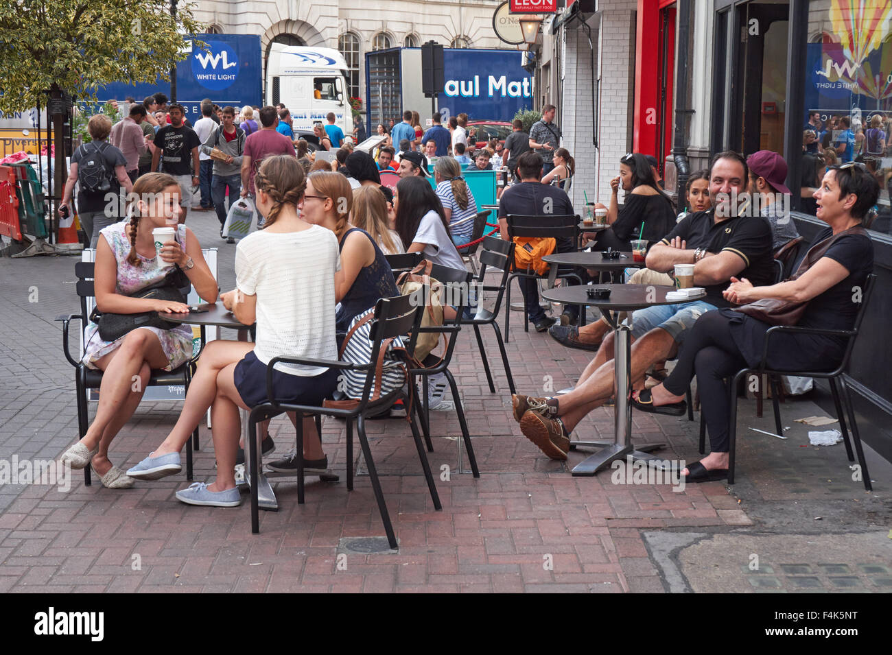 People sitting outside cafe in Soho, London England United Kingdom UK Stock Photo