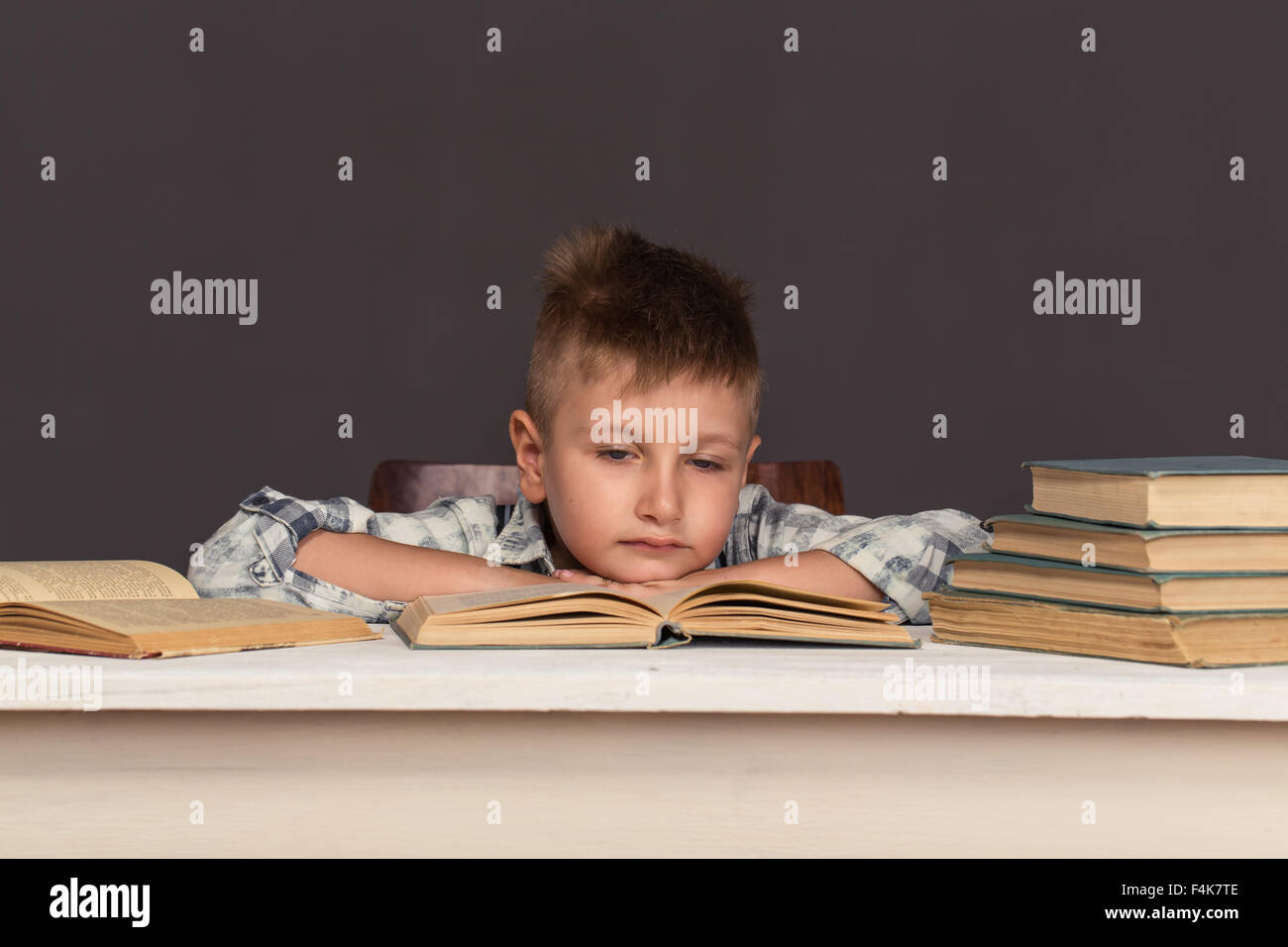 Мальчик читает книгу в коричневых тонах.