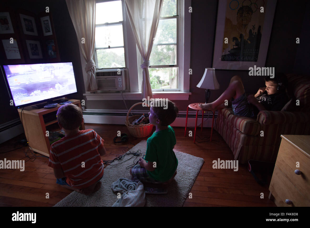 Three Young Brothers Play Video Games In Their Suburban Bedroom