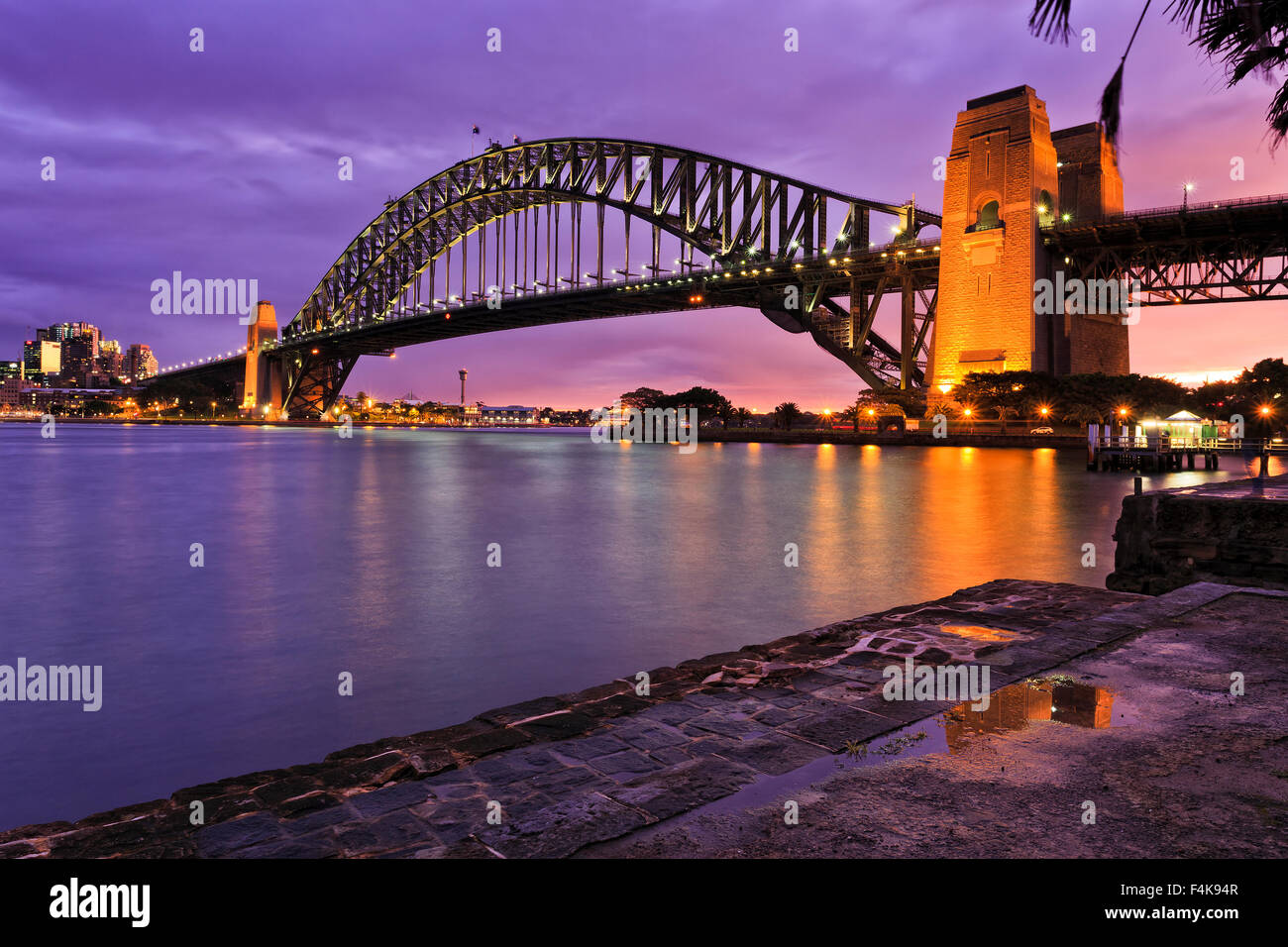 Sydney harbour bridge side view from Milsons point after fresh rain when brightly illuminated bridge arch and column reflecting Stock Photo