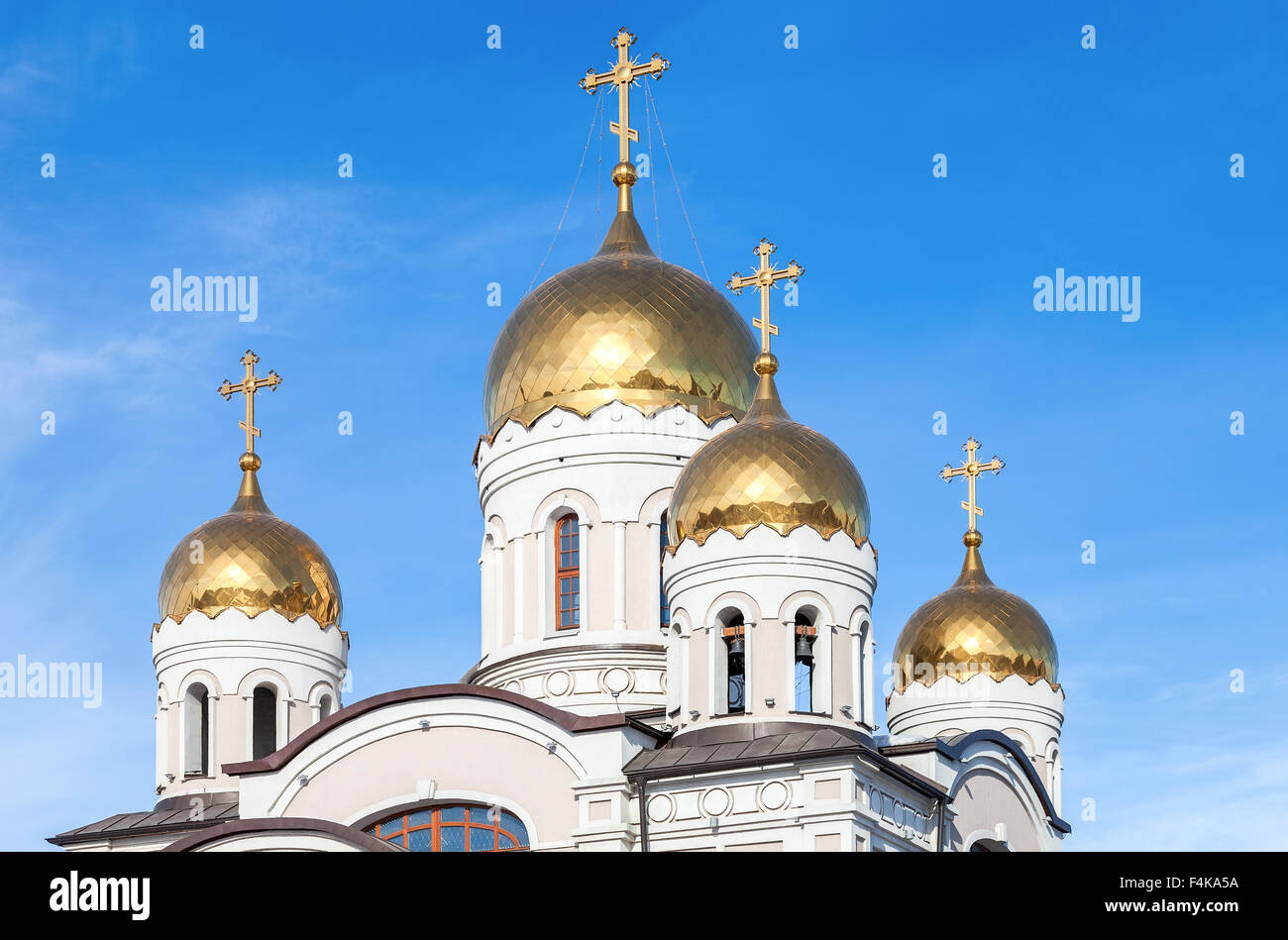 Golden domes of Russian orthodox church with cross against blue sky ...