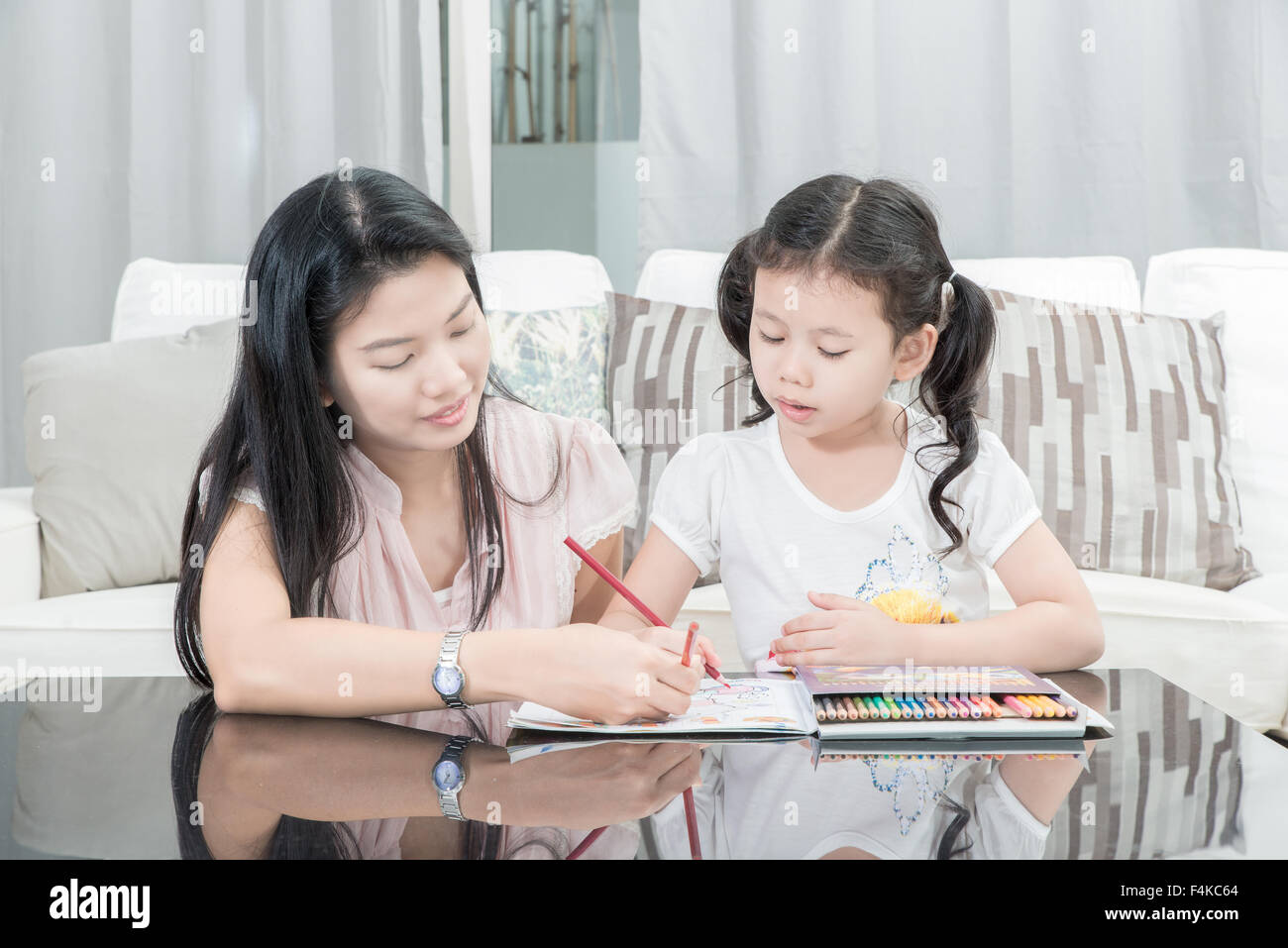 family, children and happy people concept - mother and daughter drawing at home Stock Photo