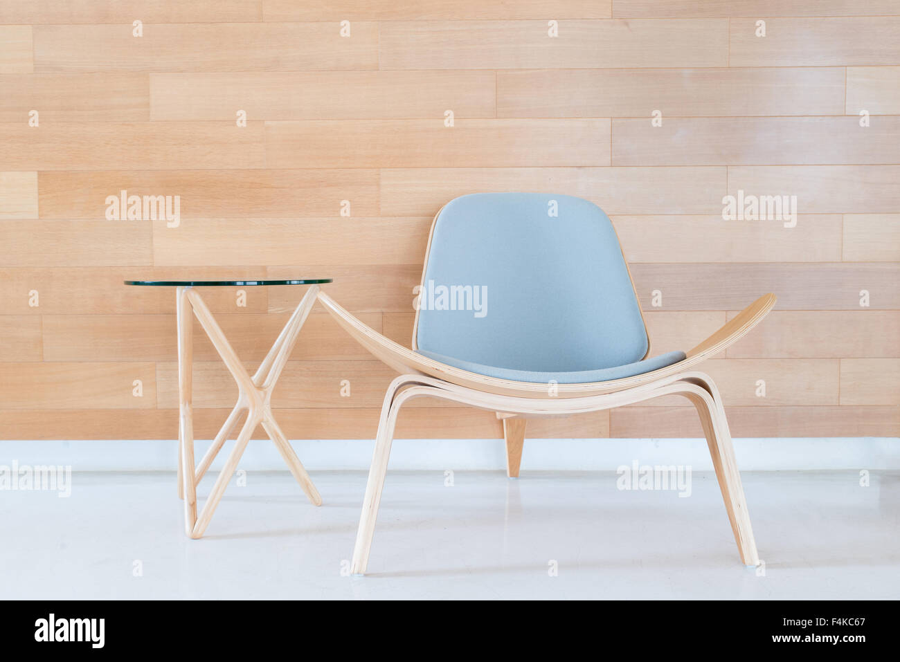 Modern chair and table with wood wall in living room Stock Photo - Alamy