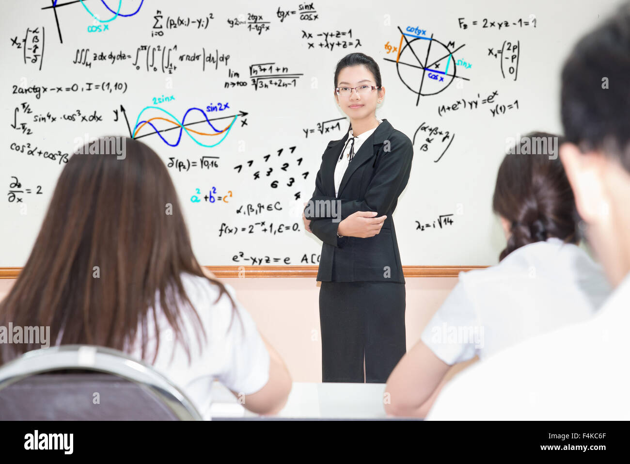 Asian teacher with a group of high school students in classroom Stock Photo