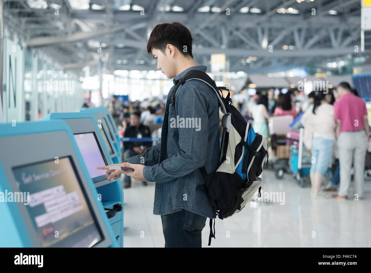 Young asian man using self check-in kiosks in airport Stock Photo