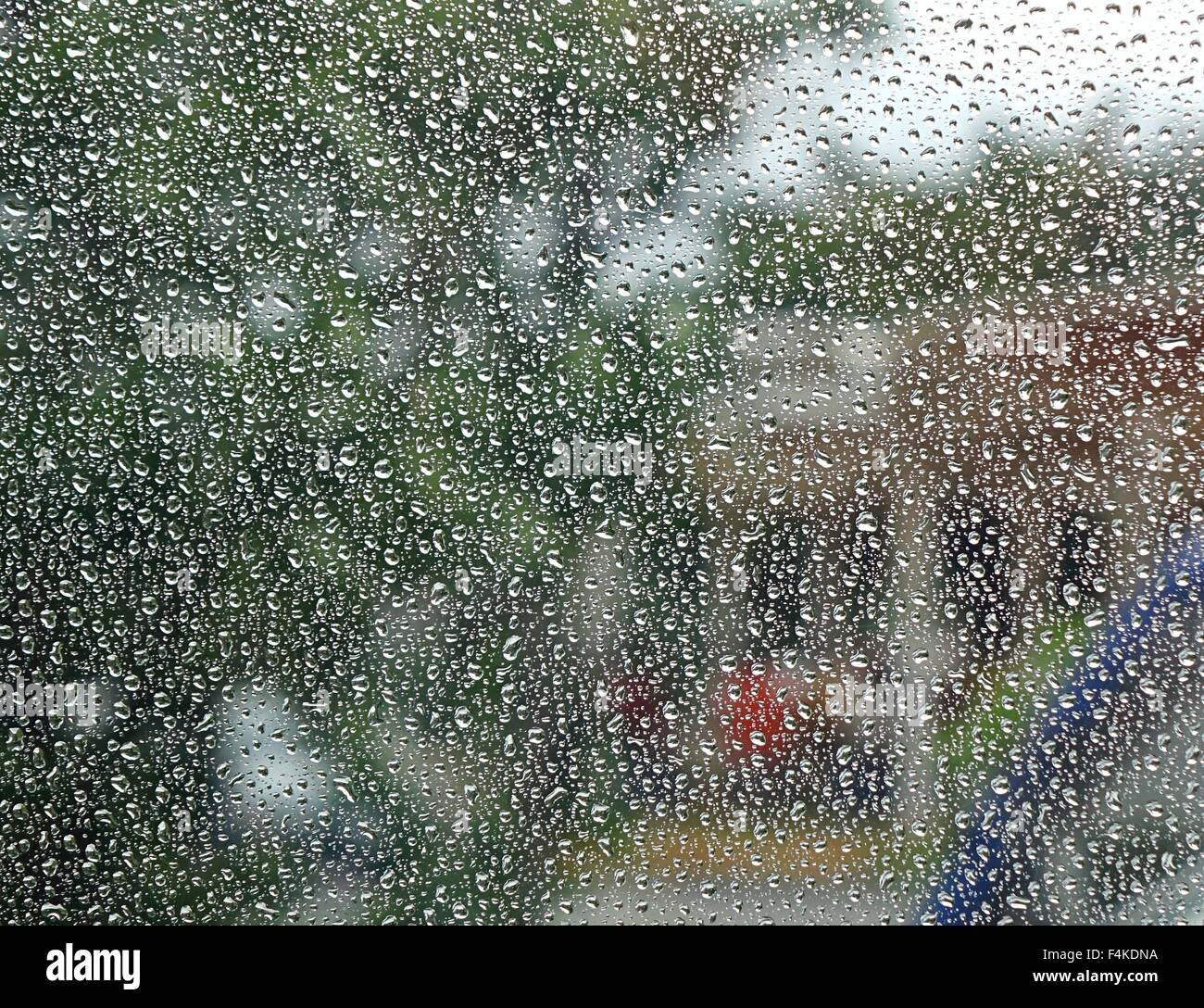 Raindrops form a dense pattern on a window pane Stock Photo
