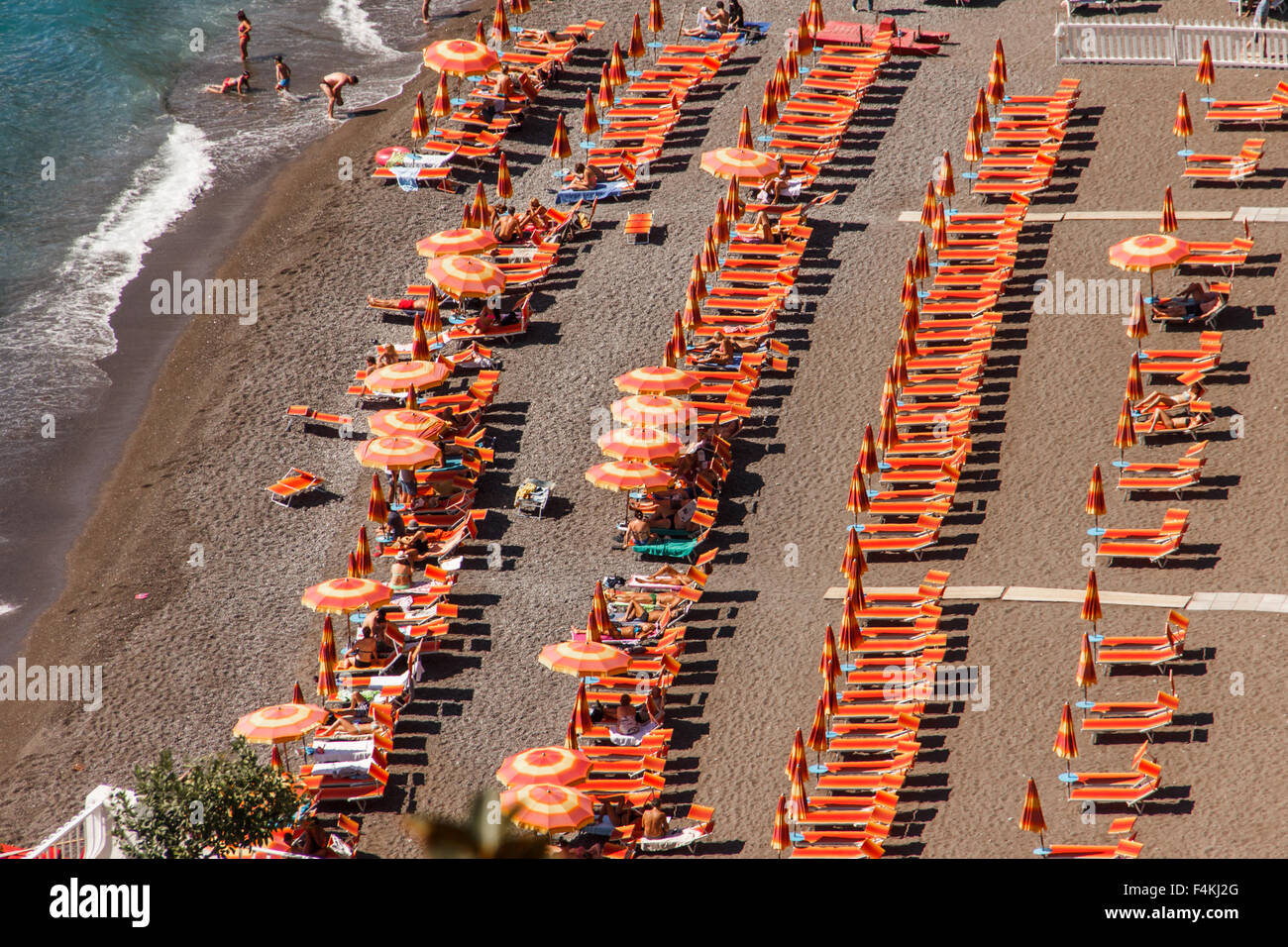 Bright orange beach chairs in rows on the sandy beach of Positano on ...