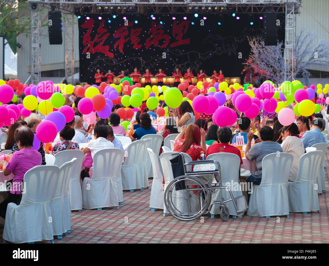 Audience holding their balloons while watching the stage show at FGS temple, Jenjarom Malaysia during chinese new year 2014. Stock Photo