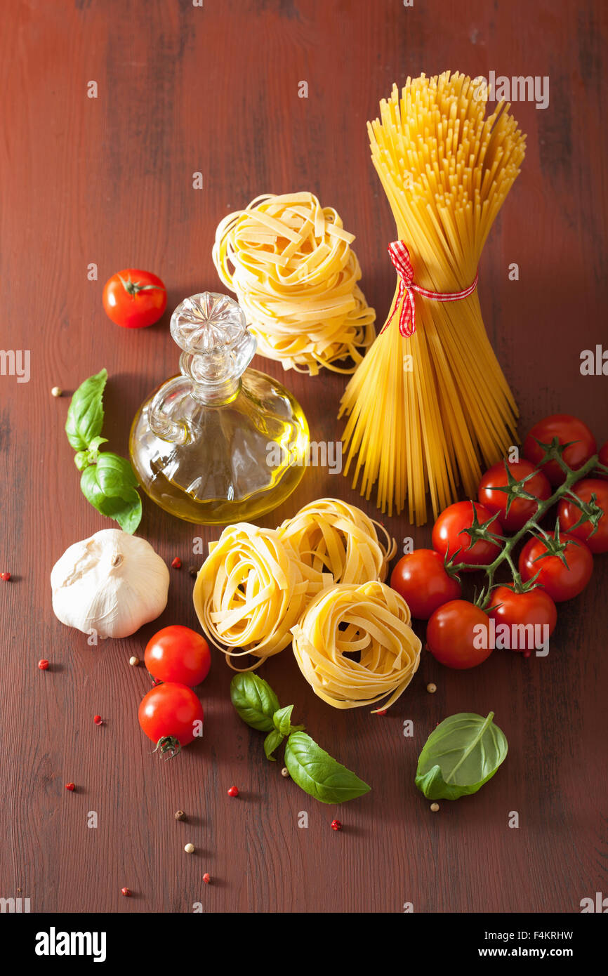 raw pasta olive oil tomatoes. italian cuisine in rustic kitchen Stock Photo
