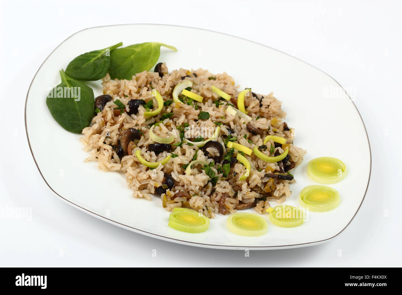 Risotto with Leek, Spinach and Olives. Isolated with clipping path. Stock Photo