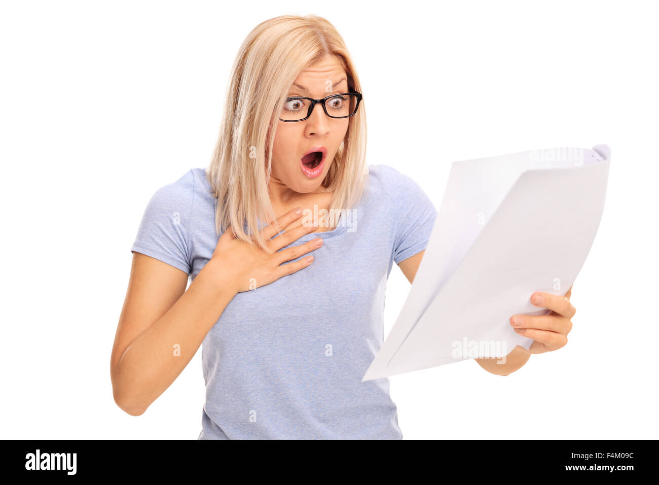 Baffled young woman looking at a piece of paper in disbelief isolated