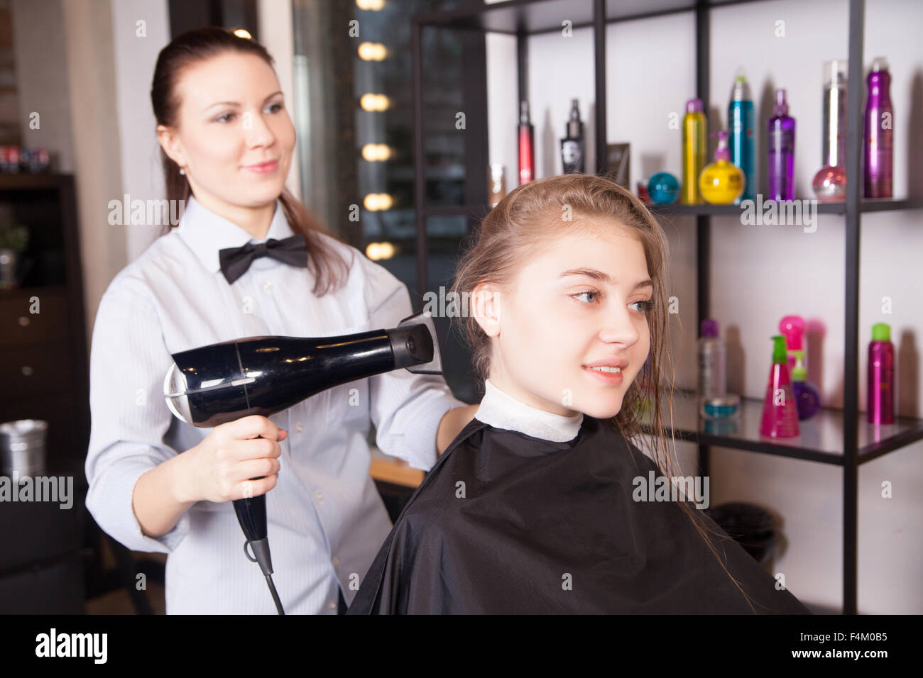 Hairstylist Drying Hair Blonde in Salon Stock Photo - Alamy