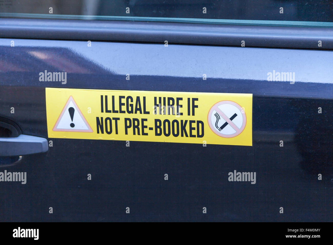 A sign on the door of a private hire car saying 'illegal if not pre booked' Stock Photo