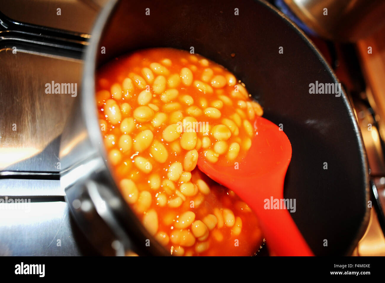 Baked beans being warmed up in a saucepan on a gas hob Stock Photo Alamy