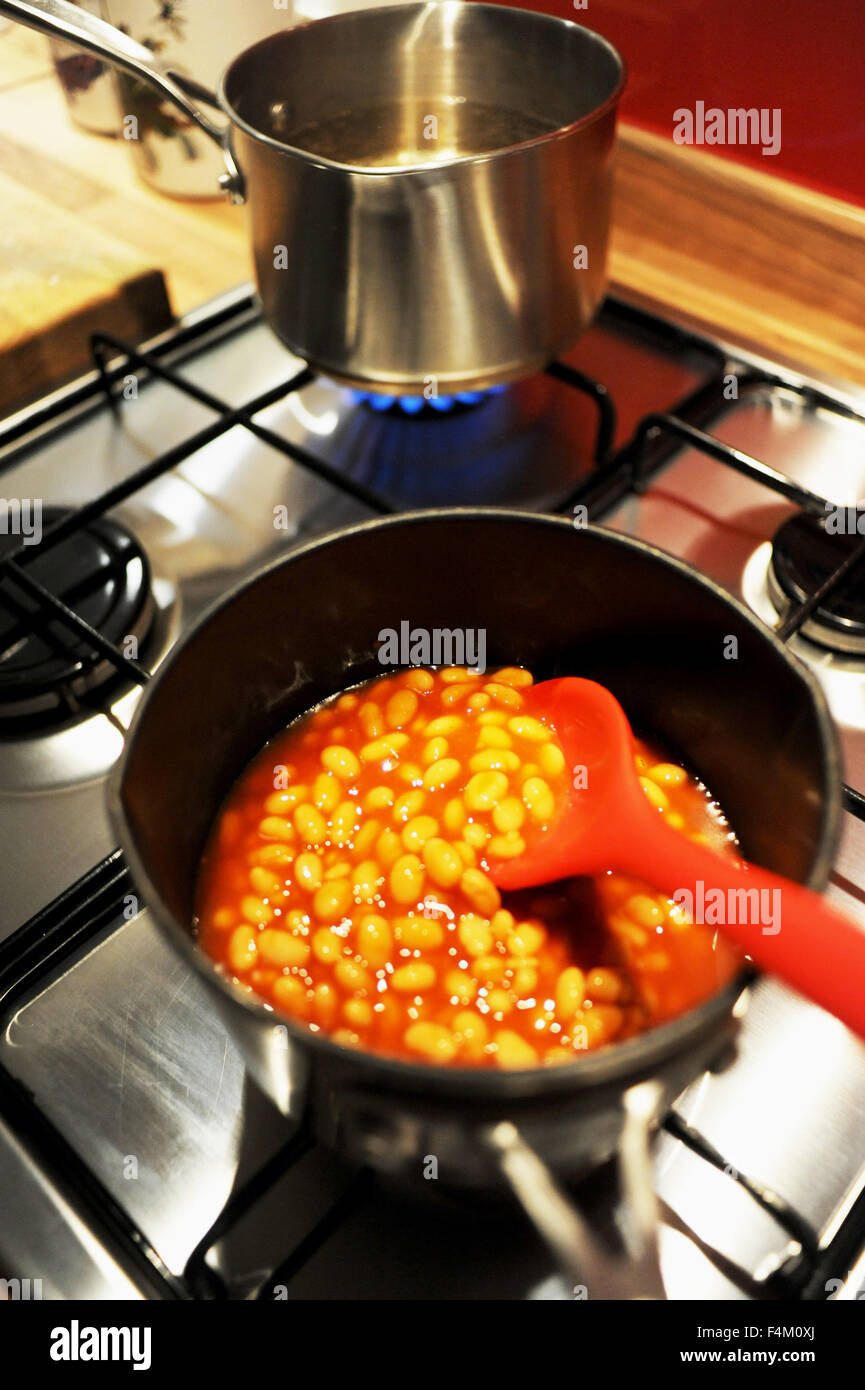 Baked beans being warmed up in a saucepan on a gas hob Stock Photo Alamy