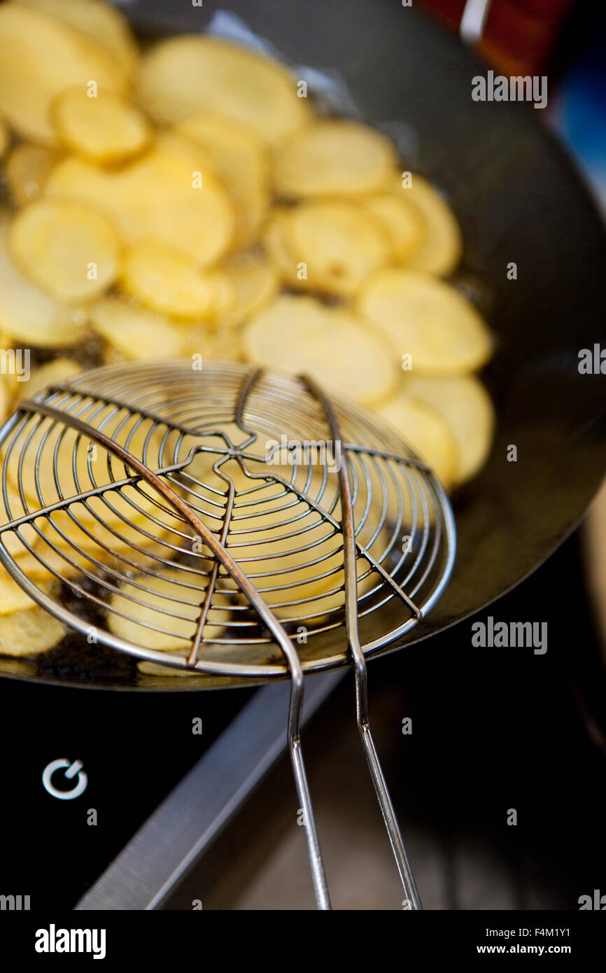 https://c8.alamy.com/comp/F4M1Y1/cooking-french-fries-in-a-pan-with-an-skimmer-F4M1Y1.jpg