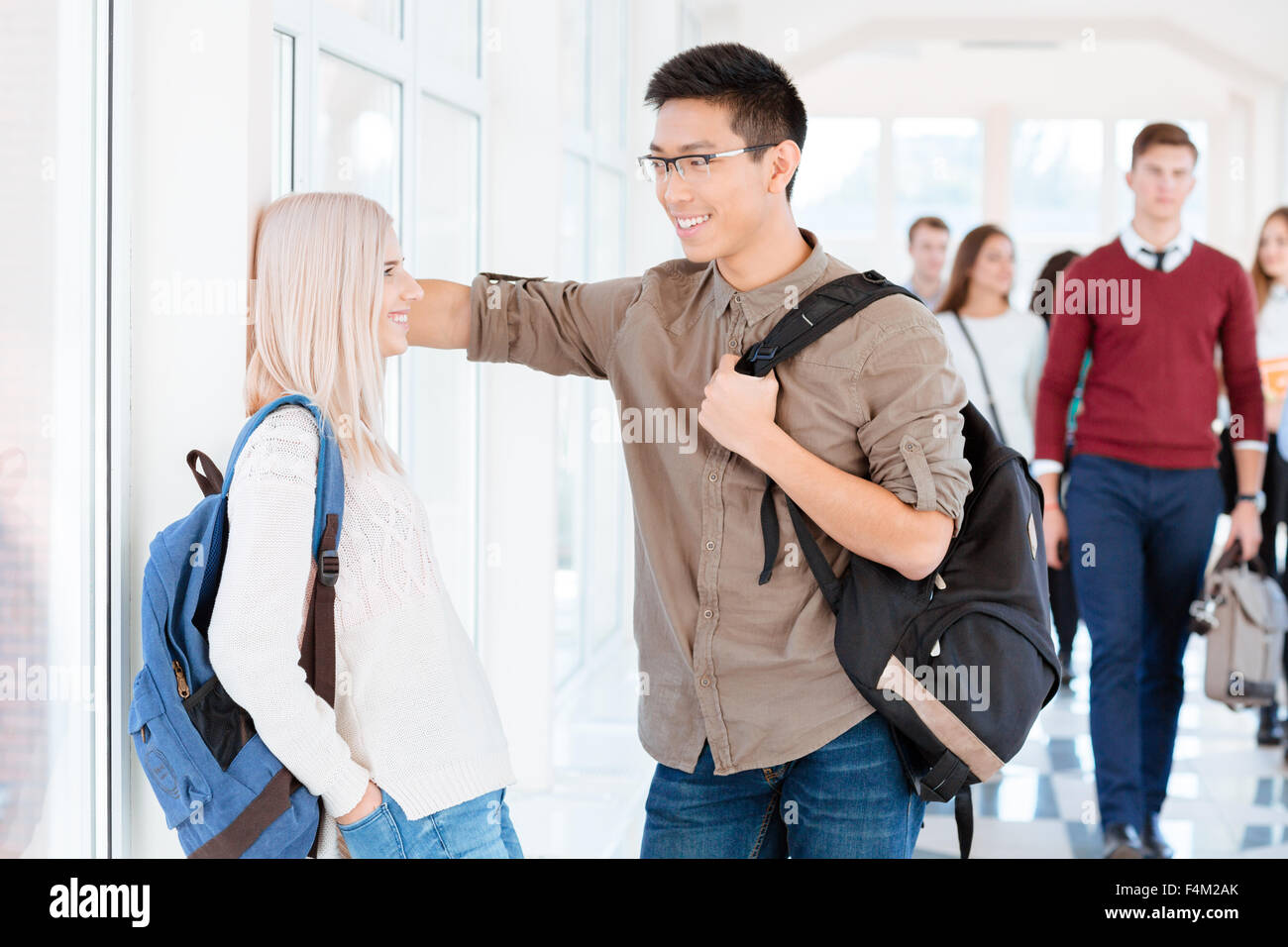 Portrait of a smiling multi ethnic students talking in university hall Stock Photo
