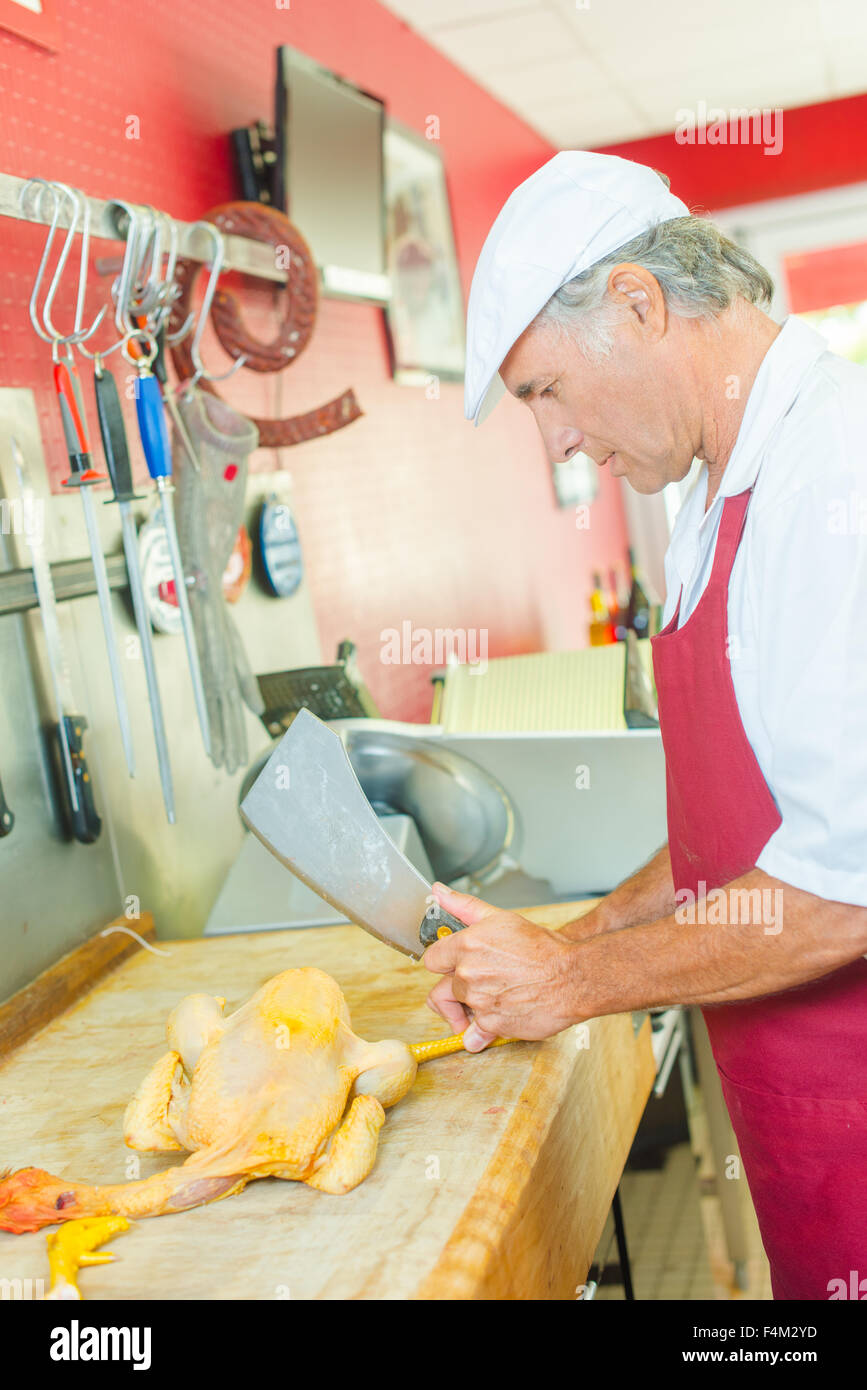 Butcher cutting up whole chicken Stock Photo