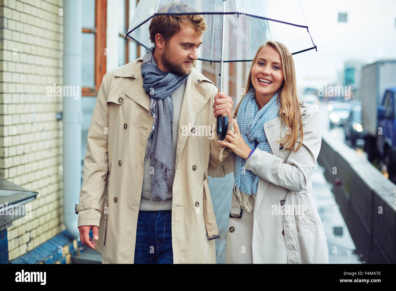 Amorous man and woman walking under umbrella Stock Photo - Alamy
