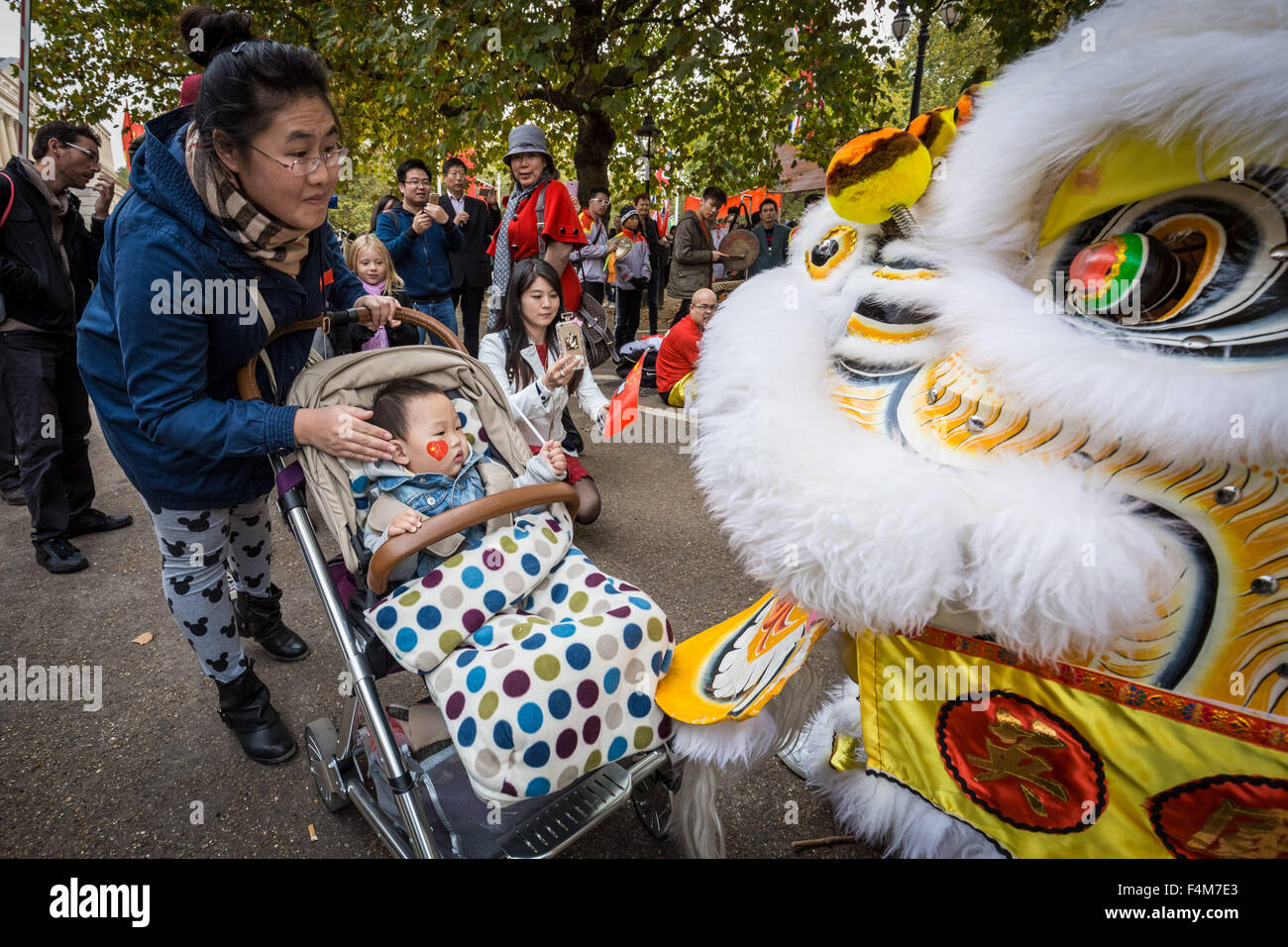 London, UK. 20th October, 2015. Chinese supporters wait for President Xi Jinping as part of the Queen’s Royal welcoming procession down The Mall beginning his state visit Credit:  Guy Corbishley/Alamy Live News Stock Photo