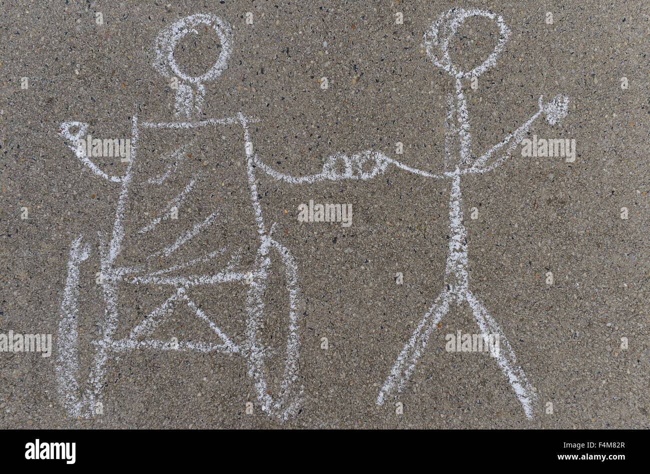 A chalkdrawing that shows a handicapped person and a non handicapped person. Stock Photo
