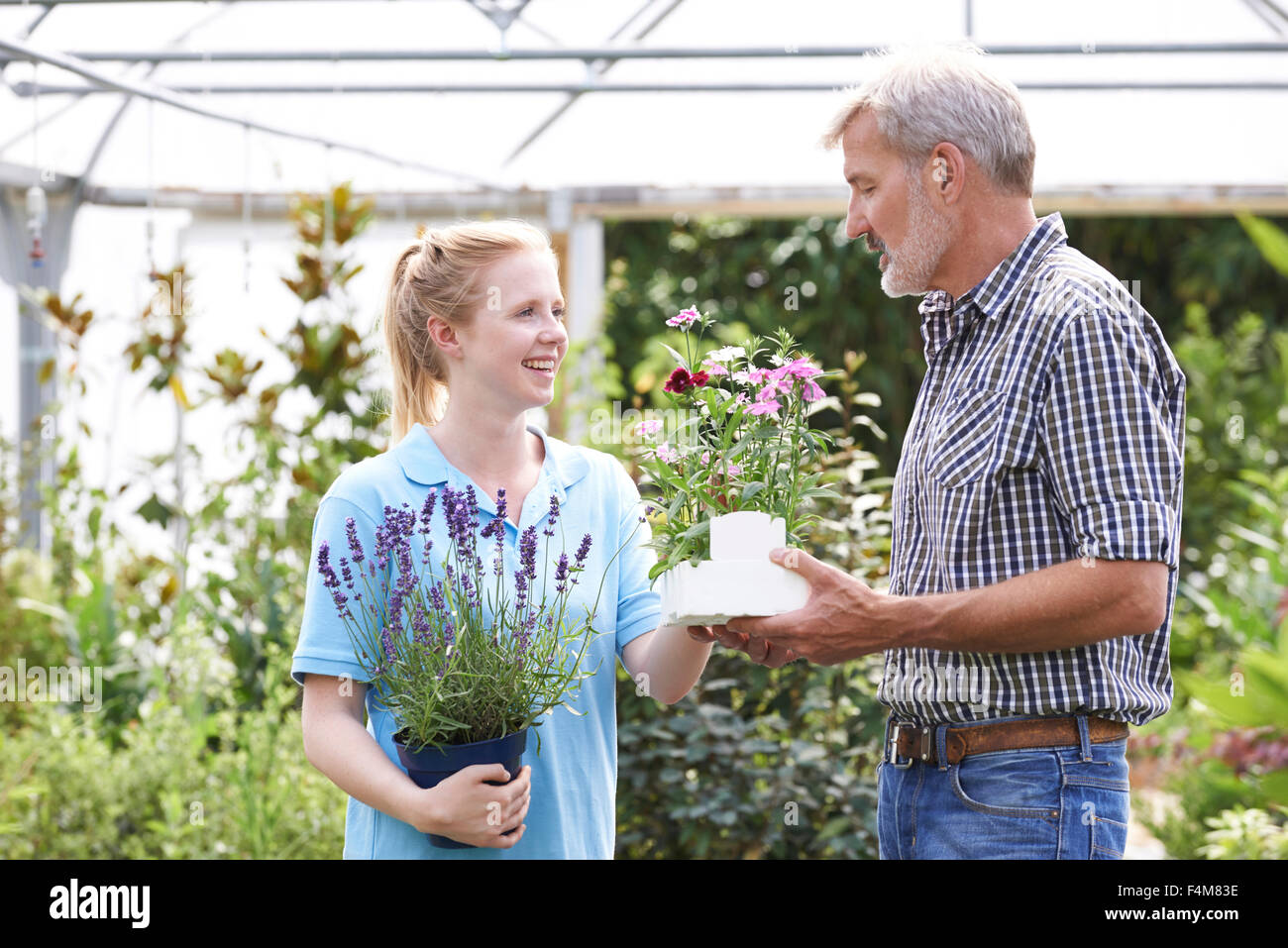 Male Customer Asking Staff For Plant Advice At Garden Center Stock Photo