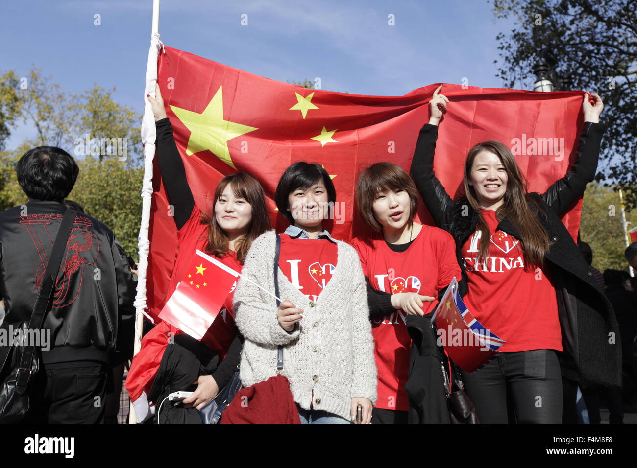 London, UK. 20th Oct, 2015. Young person poses with China flags for for taking photos in London , UK, 20th October 2015. The President of the Peoples Republic of China, Mr Xi Jinping and his wife, Madame Peng Liyuan, are paying a State Visit to the United Kingdom as guests of The Queen. Credit:  CPRESS PHOTO LIMITED/Alamy Live News Stock Photo