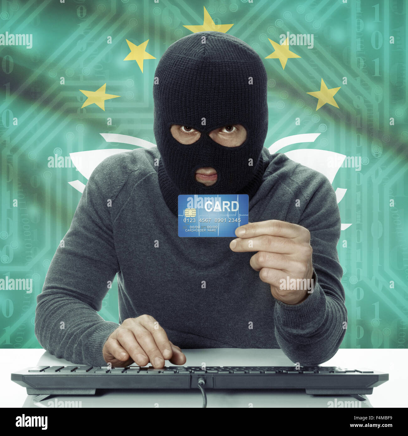 Dark-skinned hacker with credit card in hand and flag on background ...
