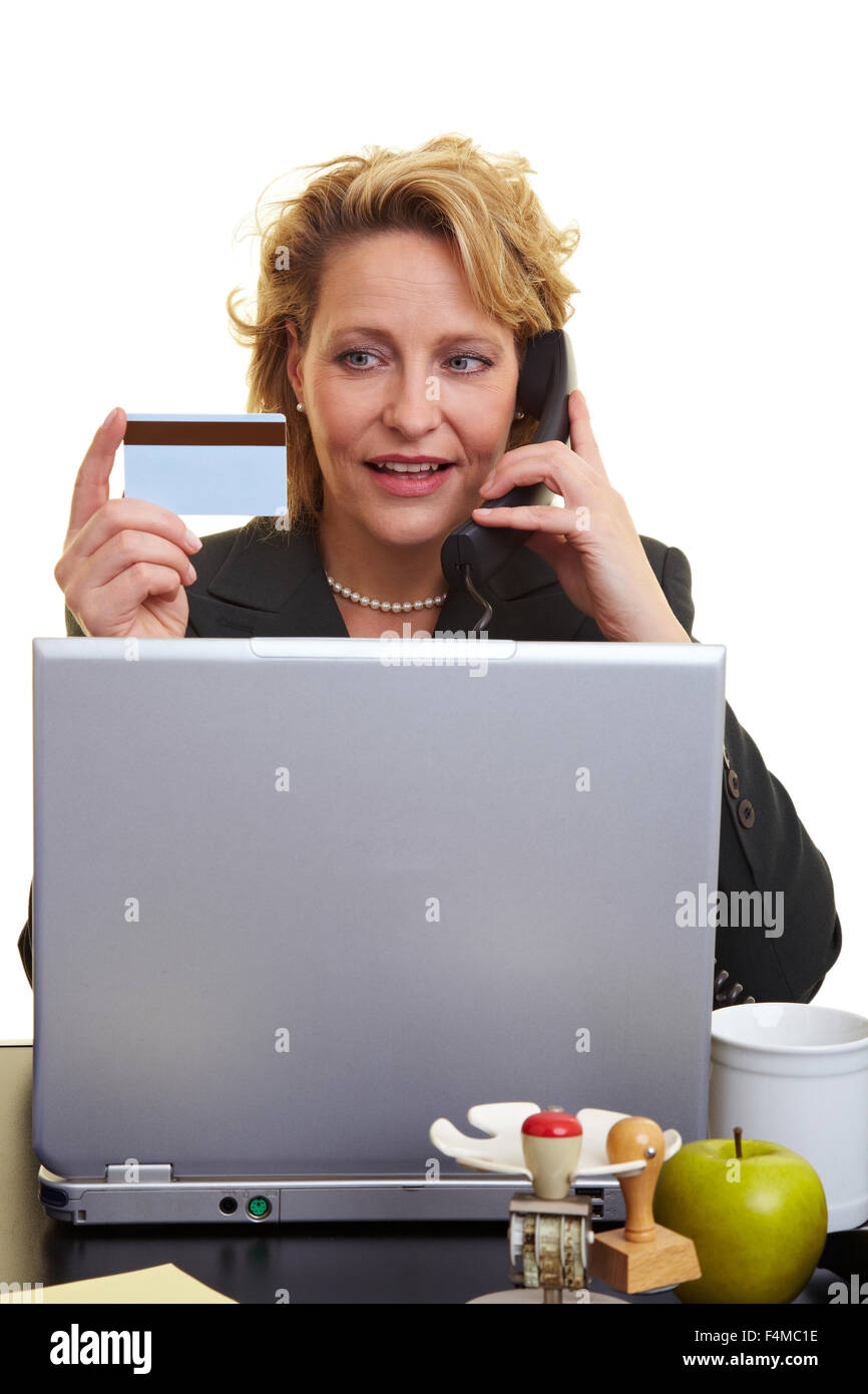 Woman using a credit card on the phone and computer Stock Photo