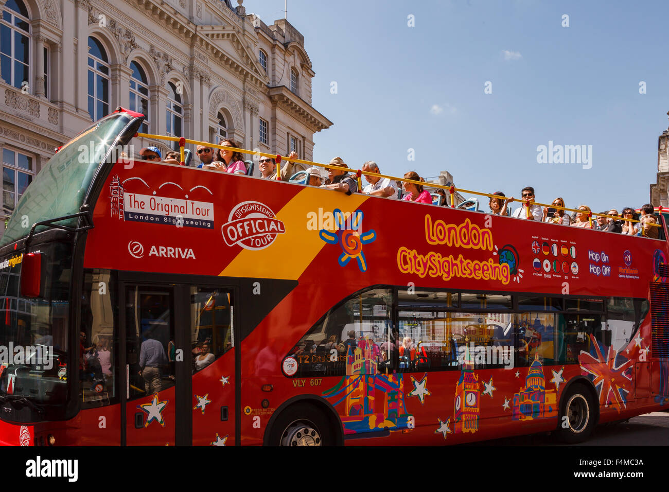Red open topped London sightseeing bus full of tourists. Stock Photo