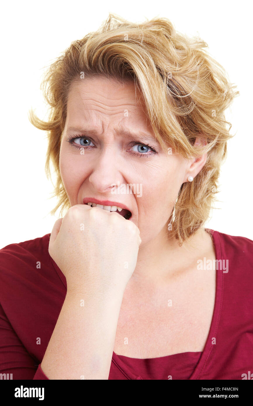 A frustrated woman biting on her fist Stock Photo