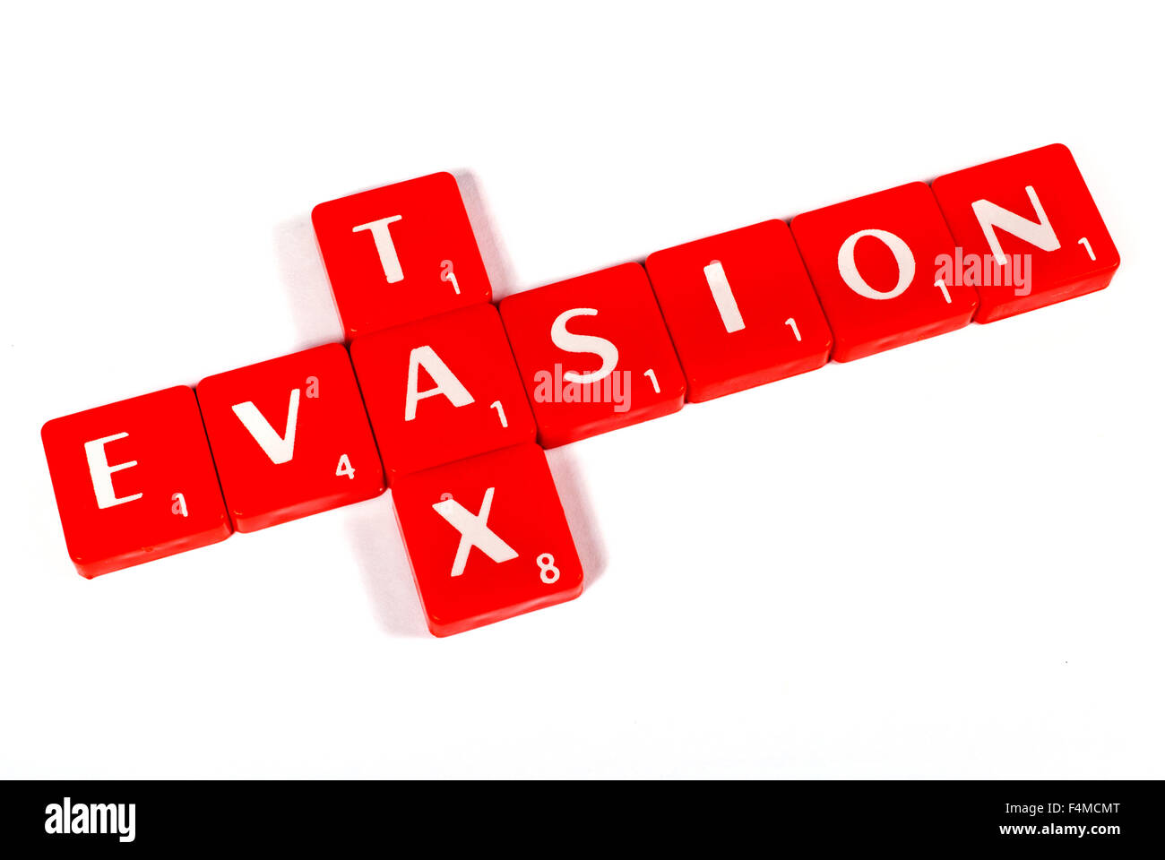 TAX EVASION spelt out with red lettered tiles over a white background. Stock Photo