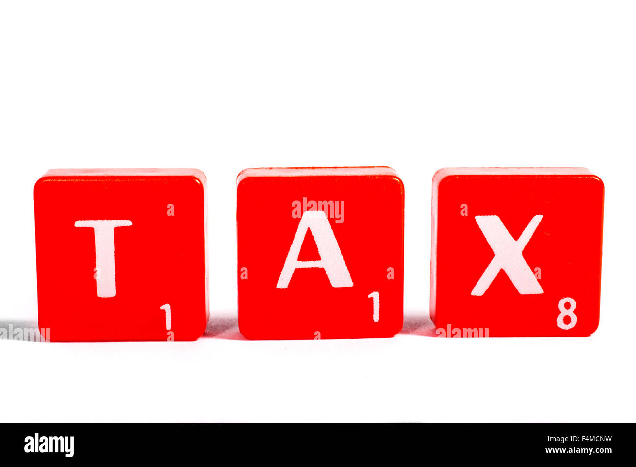 TAX spelt out with red lettered tiles over a white background. Stock Photo