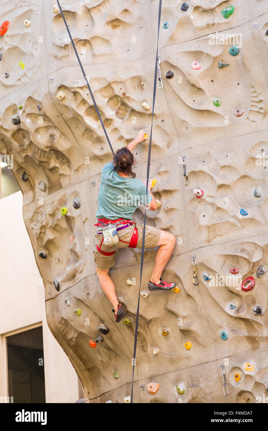 A man climbs a rock climbing wall in downtown Asheville, North Carolina