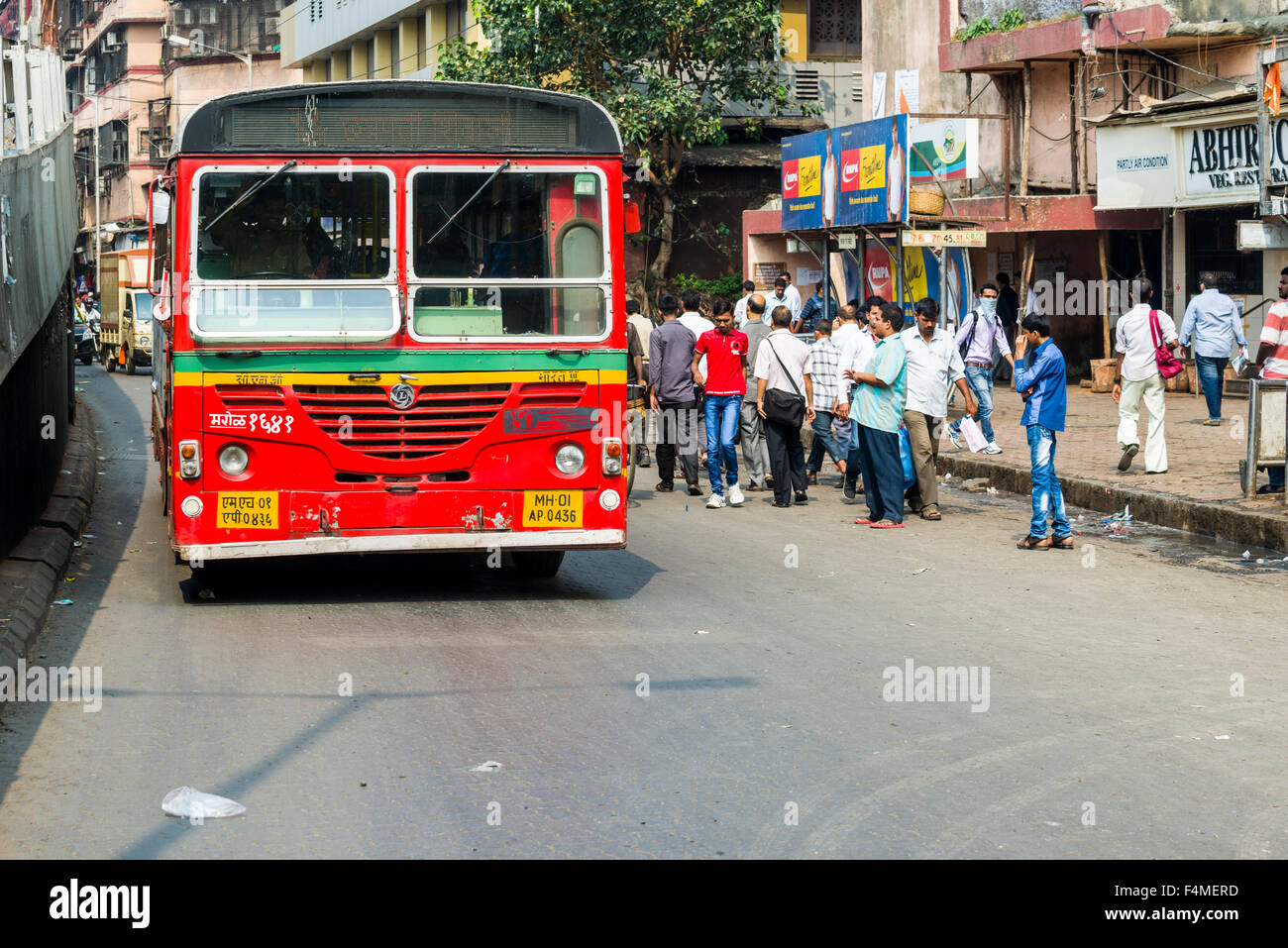 One of thousands red busses of the public transport system is driving through a market area Stock Photo