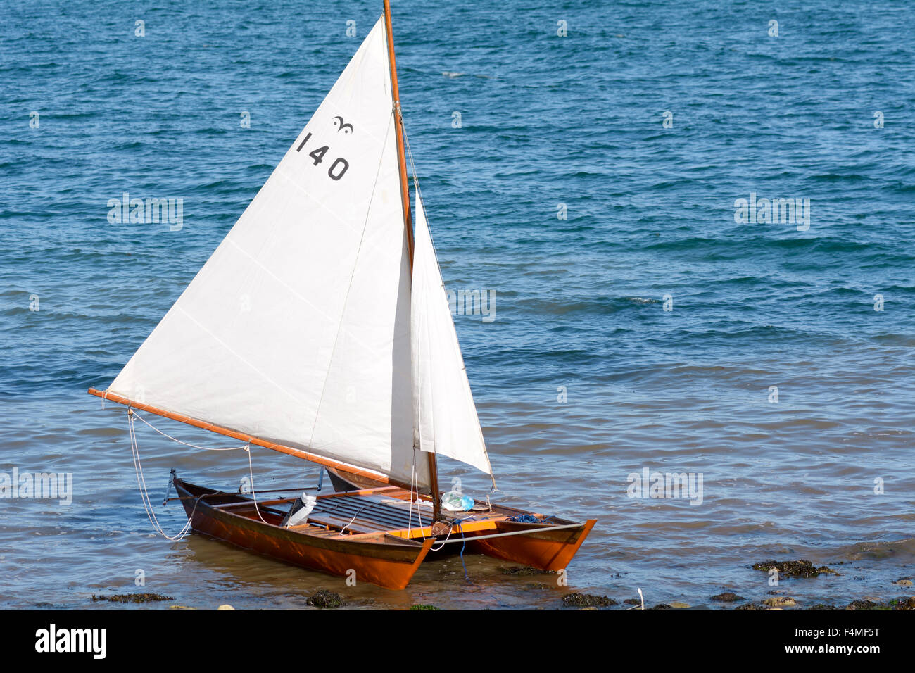 Small catamaran sailing boat on the shore at Babbacombe 