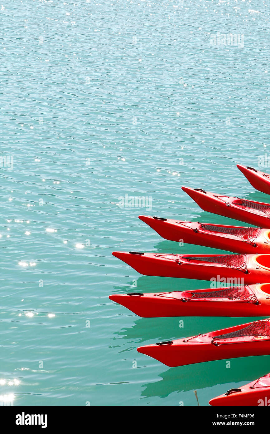 Red kayaks in a lake, in a vertical composition Stock Photo