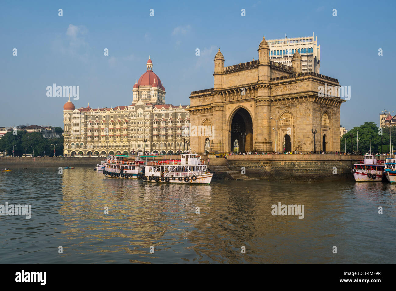 The Gateway of India in the suburb Colaba with the Taj Mahal Palace Hotel behind it, seen from a ferryboat across the bay Stock Photo