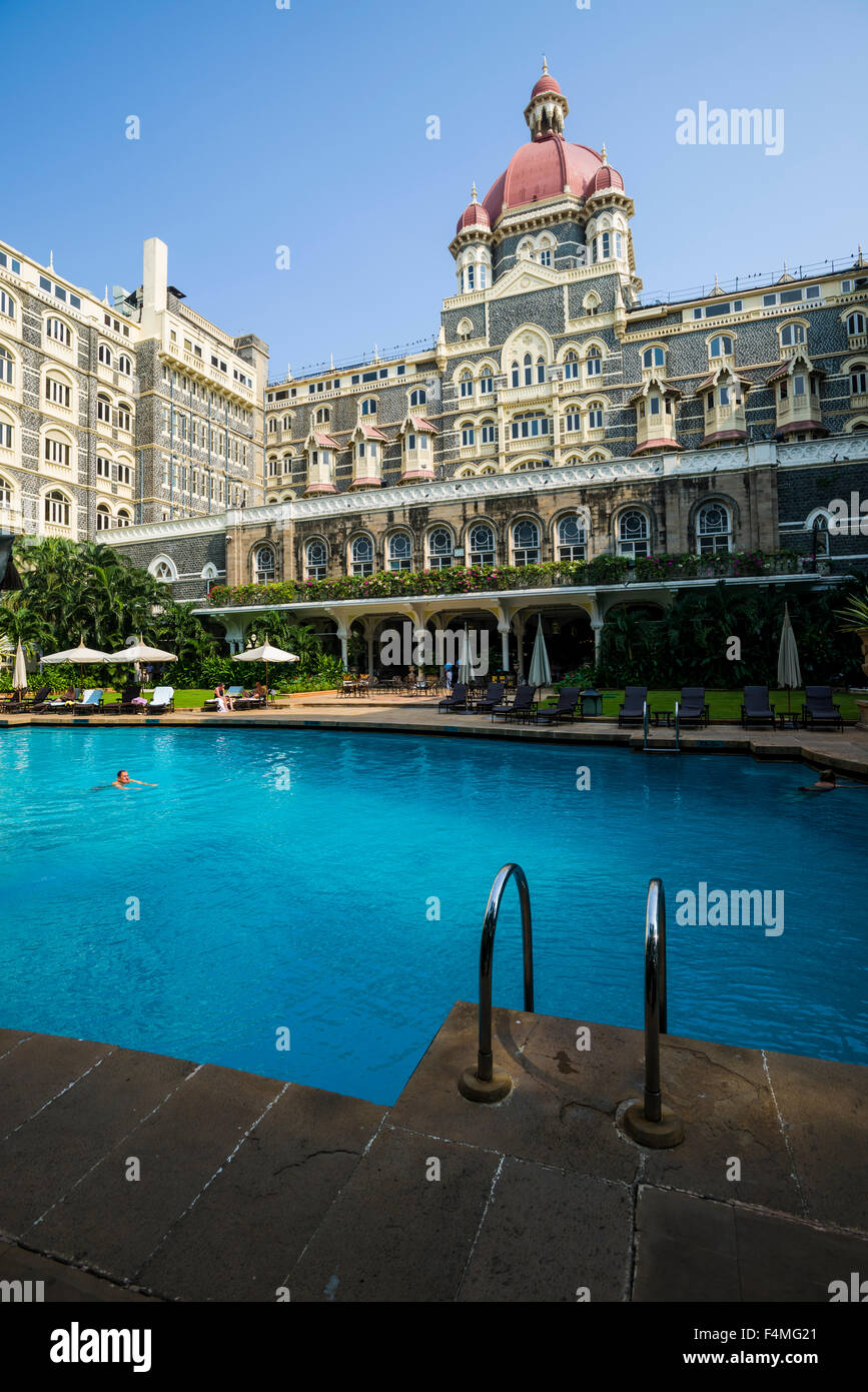 The swimming pool inside the Colaba Taj Mahal Palace Hotel courtyard is filled with blue water, reflecting the hotel's facade Stock Photo
