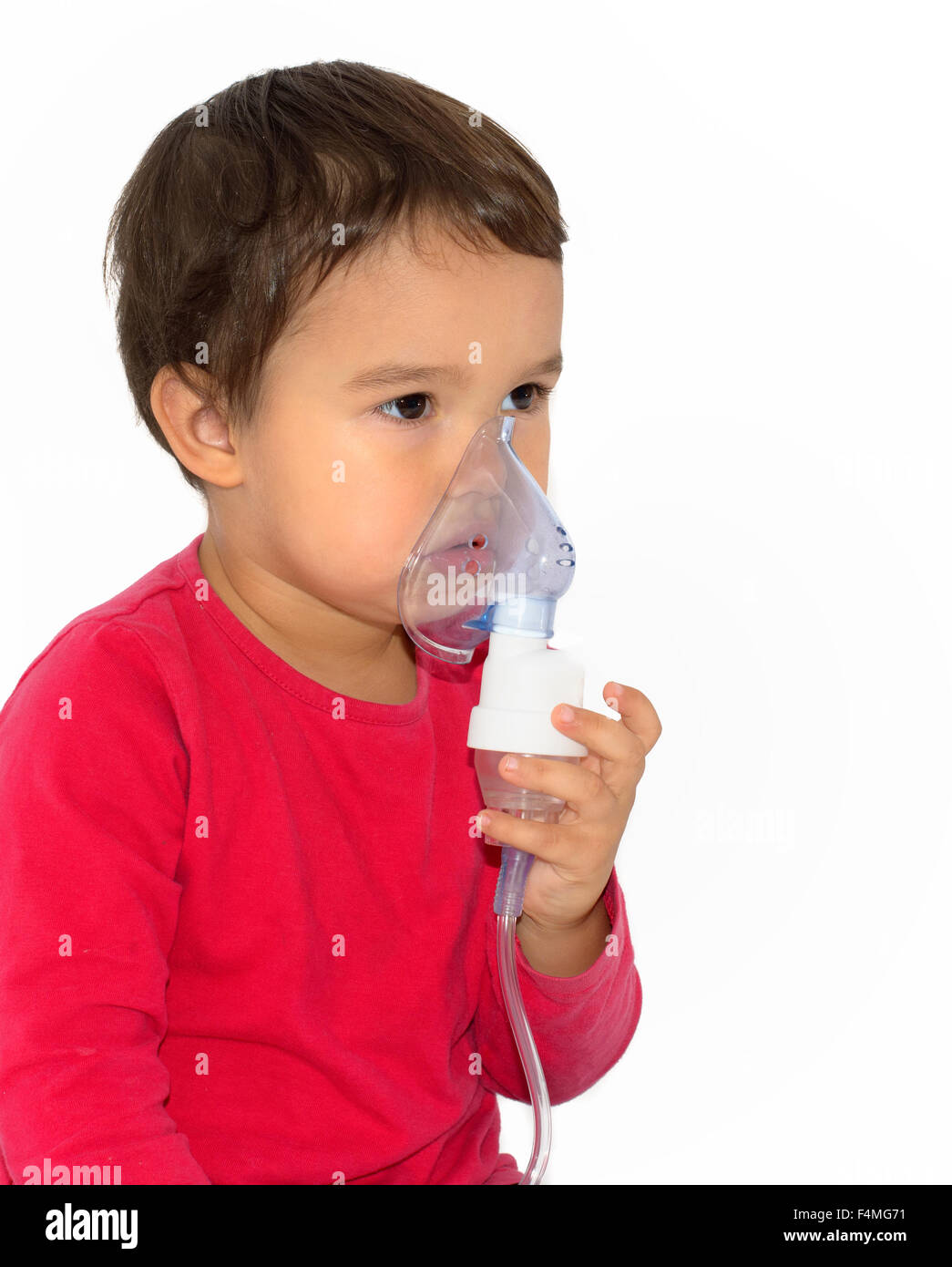 Little girl making aerosol treatment with a rubber masks Stock Photo