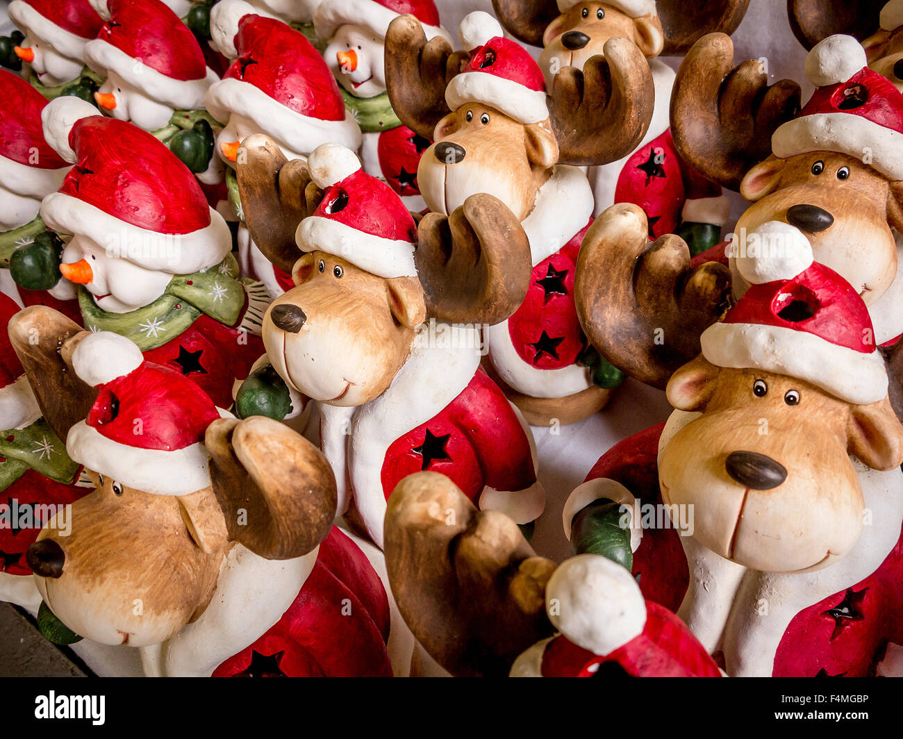 Reindeer and snowmen ornaments in Father Christmas outfits lined up for sale at a garden centre Stock Photo