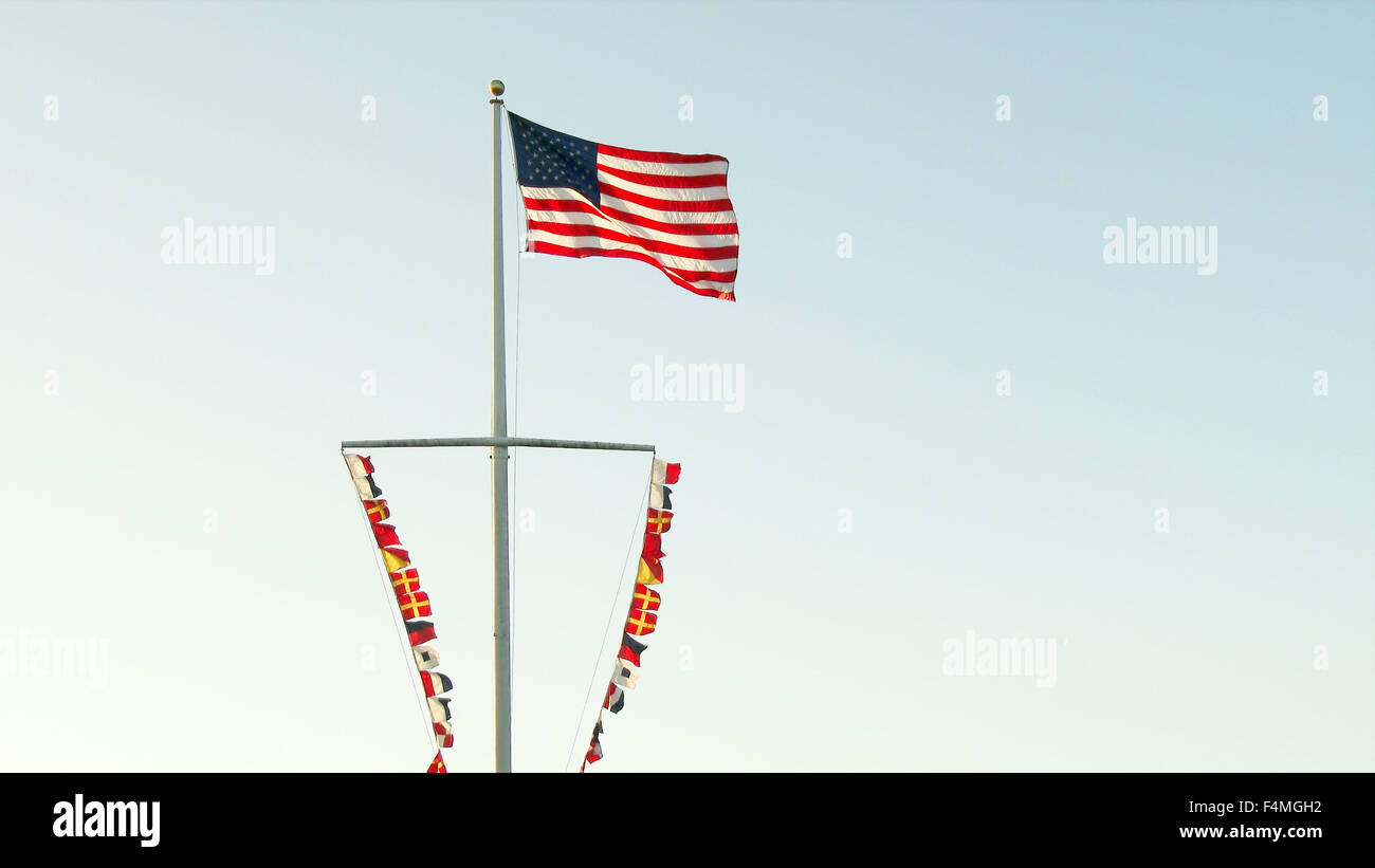 The American flag and multiple nautical flags on ship's mast in Santa